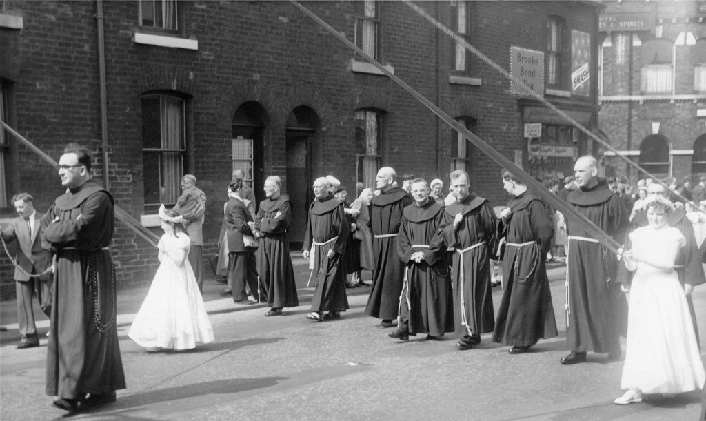 Manchester Monastery Whit walk around 1960. The friars walk behind the banner with the girls holding the banner strings.